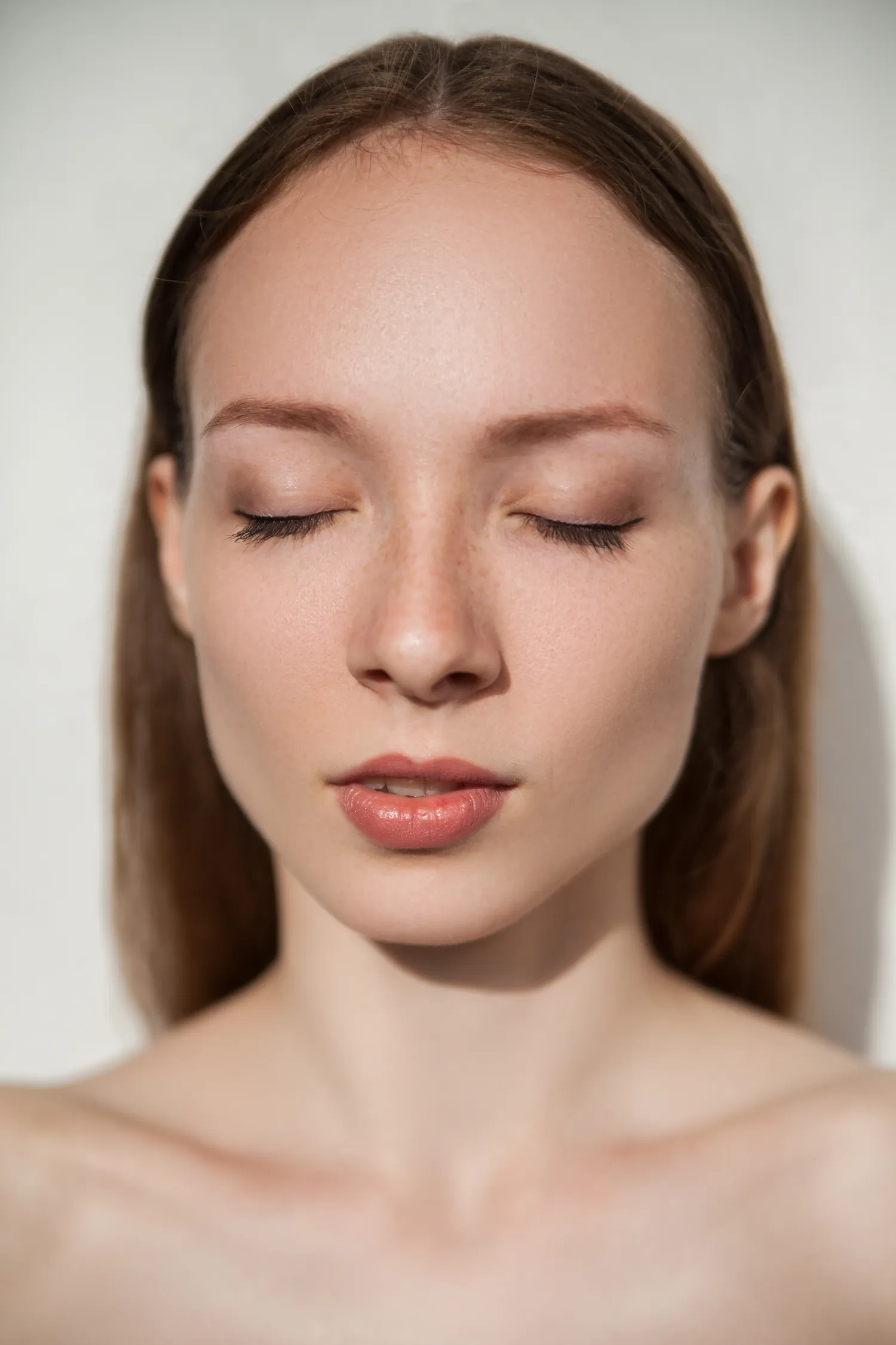 A woman with calm, glowing skin, eyes closed